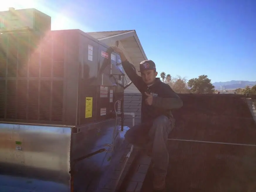HVAC technician performing Boiler Repair on a rooftop unit in Downers Grove